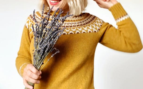 Woman wearing wool jumper and holding dried lavender